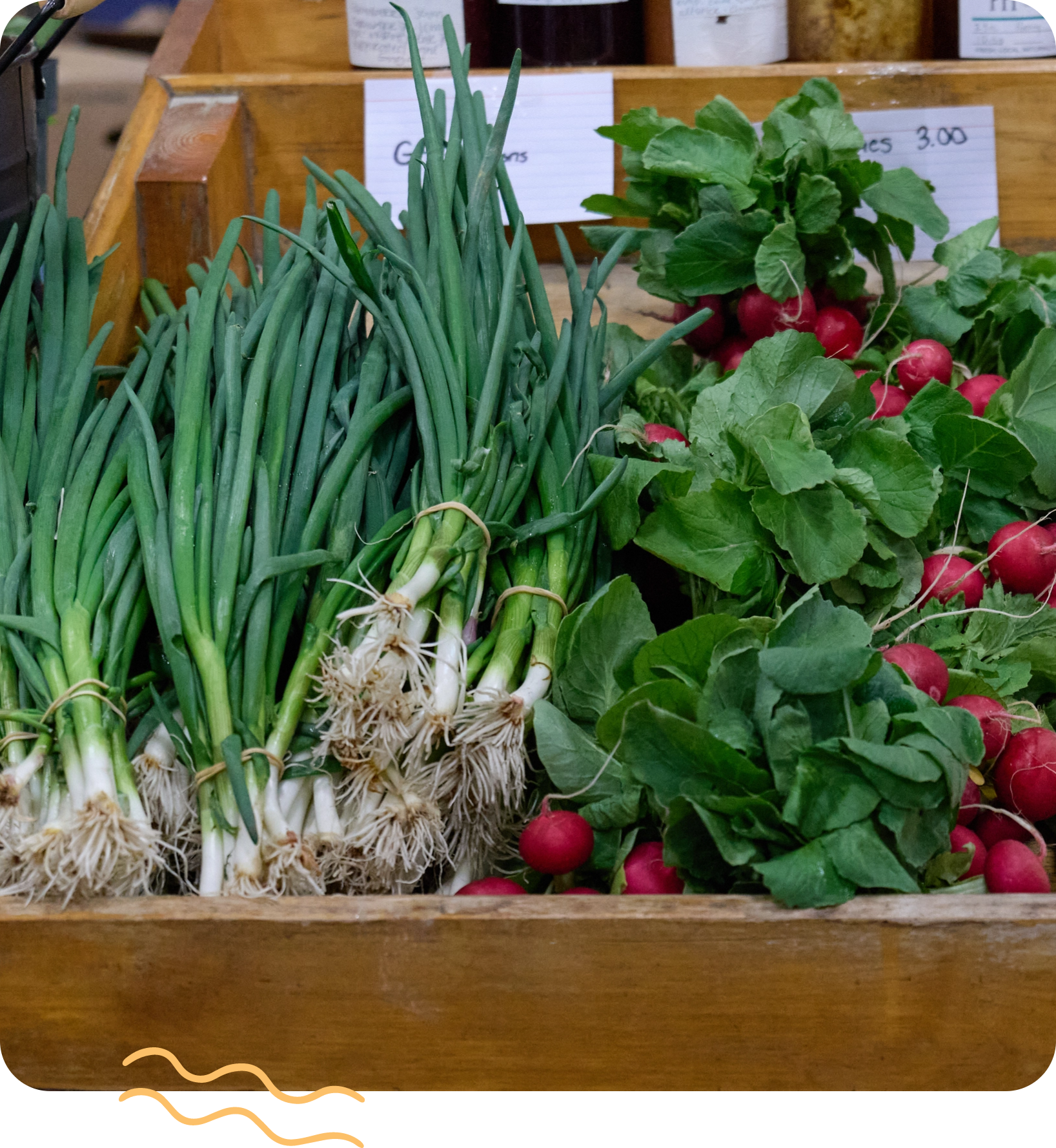Produce on display in a wooden box at a farmer's market Produce on display in a wooden box at a farmer's market