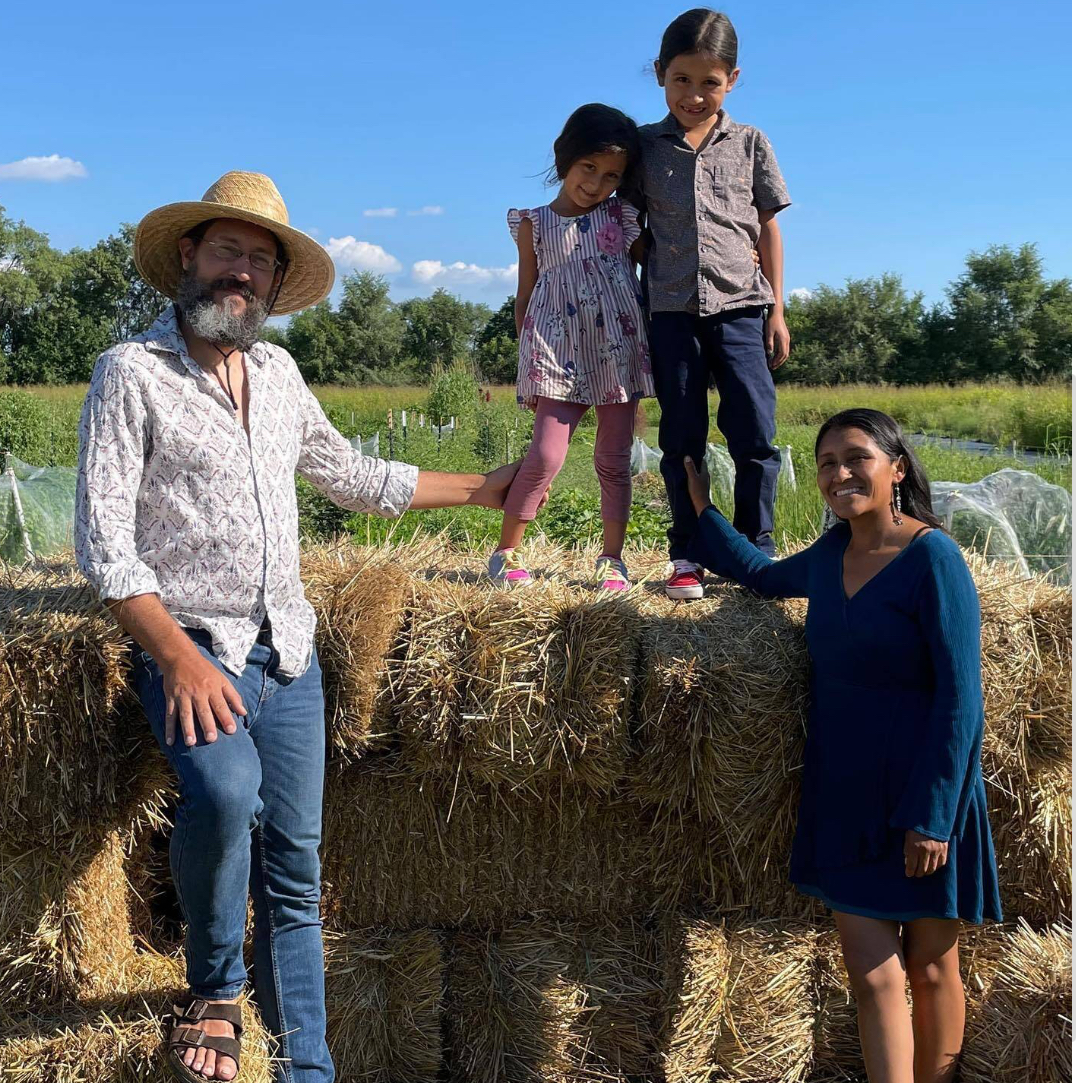 Family of four standing in front of hay bales Family of four standing in front of hay bales