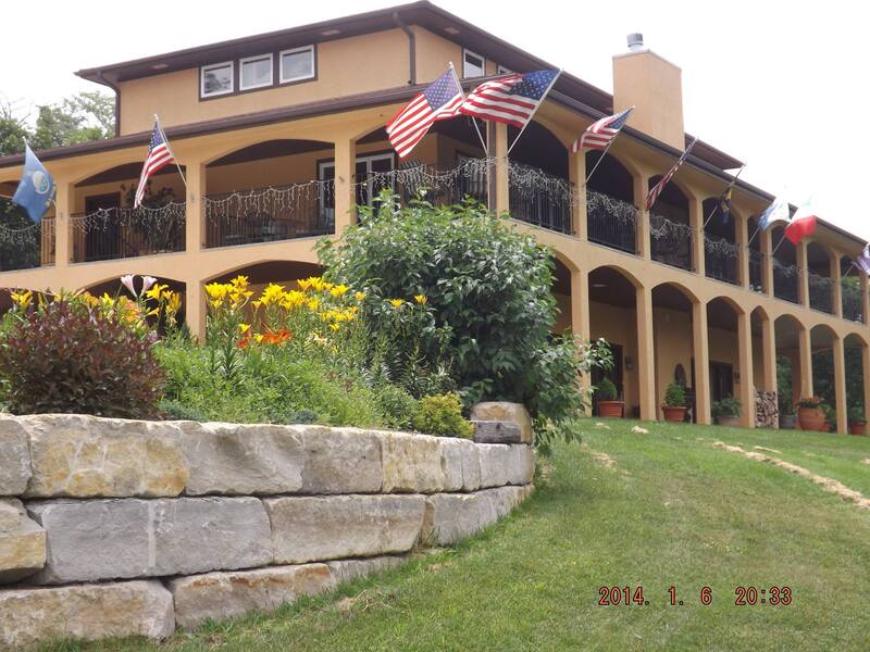 A two story building with a wrap-around balcony sits on front of pretty landscaping A two story building with a wrap-around balcony sits on front of pretty landscaping
