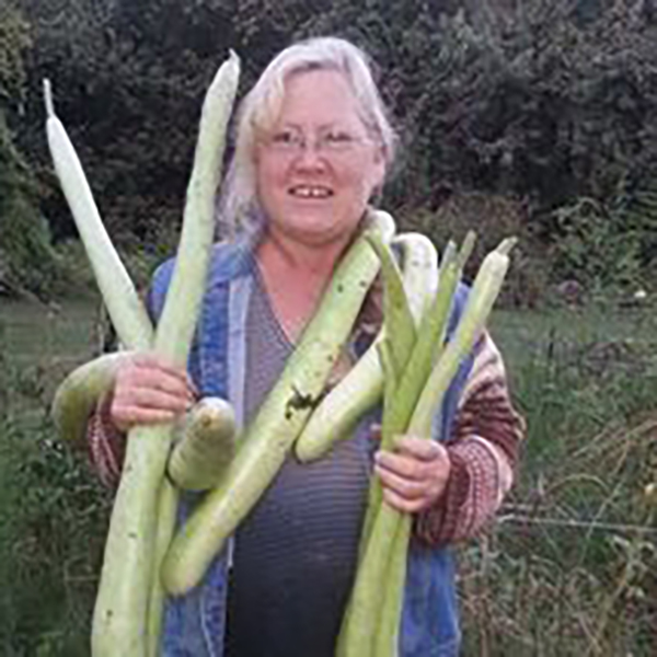 Precious Petals vendor holding vegetables Precious Petals vendor holding vegetables