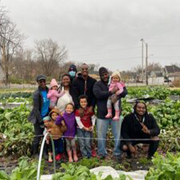The Young family poses in front of rows of crops The Young family poses in front of rows of crops